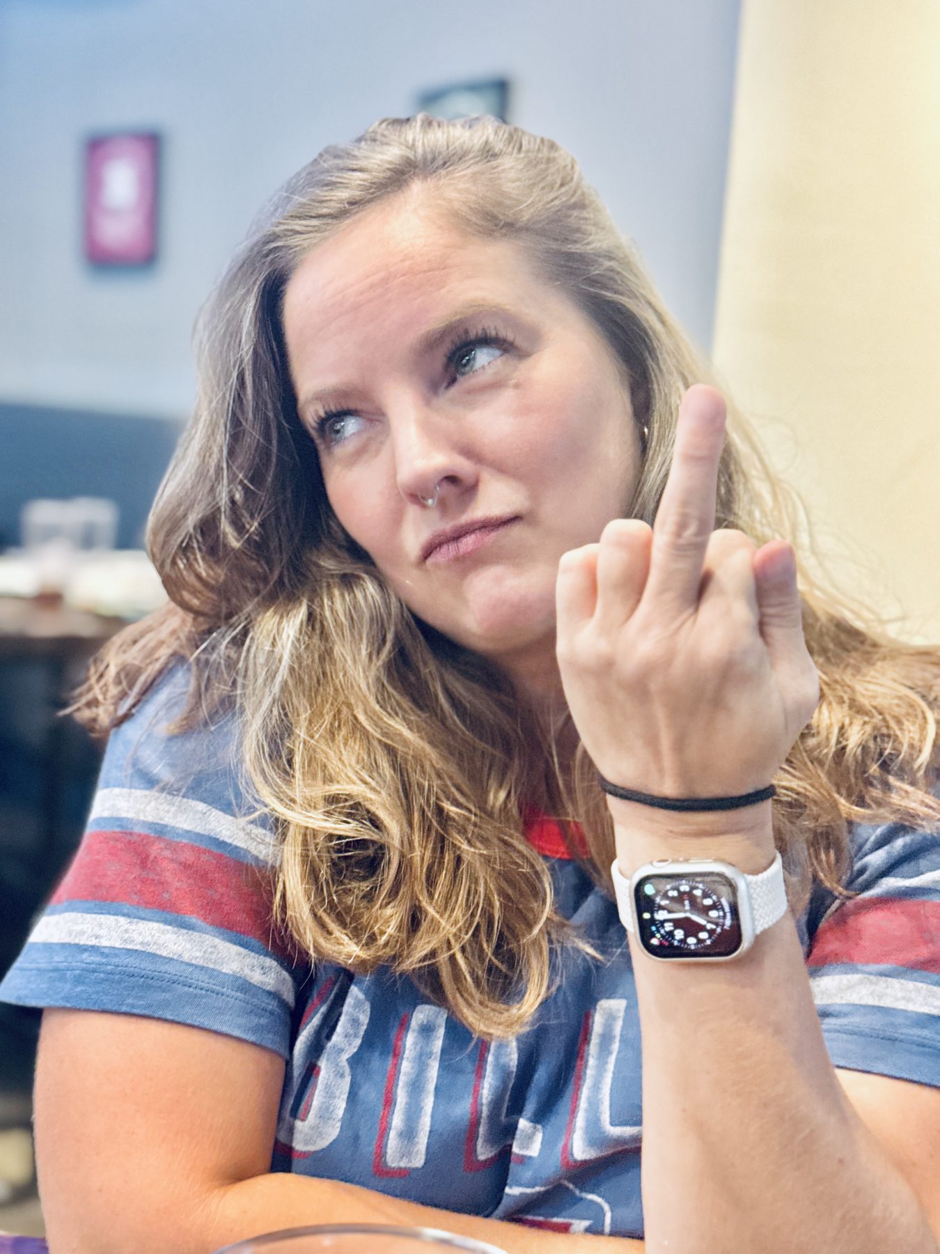 Aleasha in a Buffalo Bills shirt giving the camera a side-eye and holding up her middle finger.